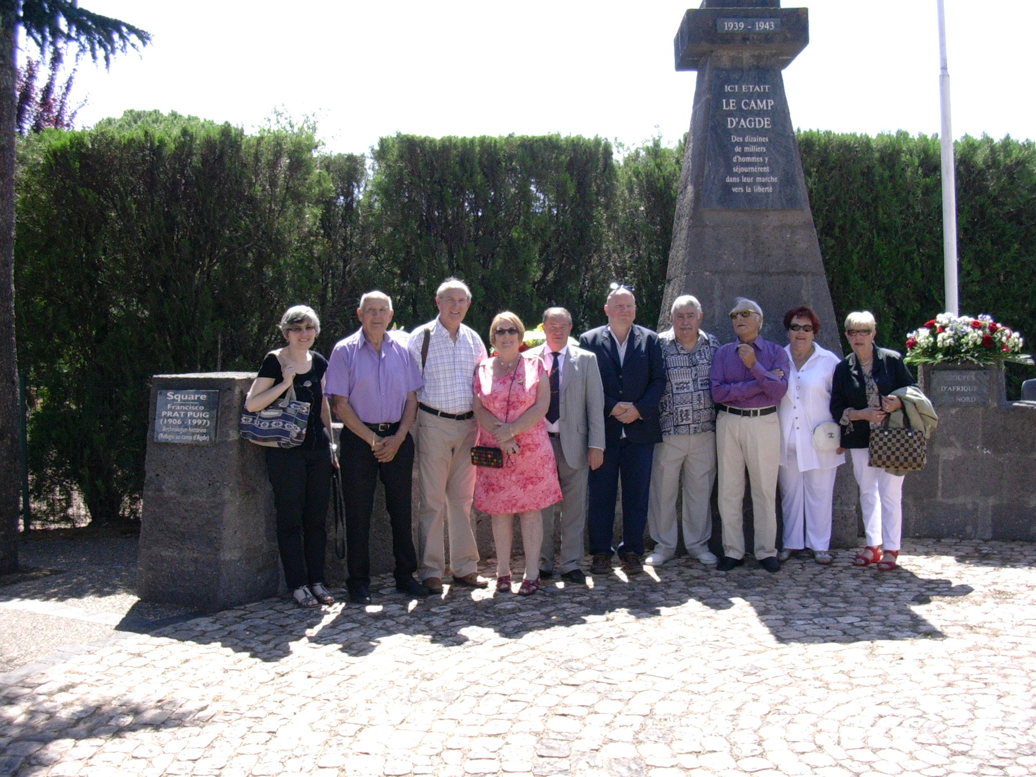 photo des membres de l'association devant le monument à l'effigie du camp